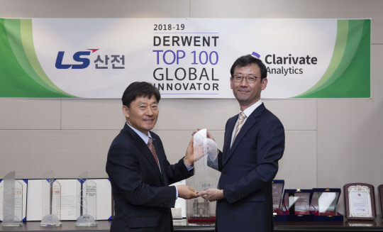 이학성 LS산전 DT 총괄사장(왼쪽), 김진우 클래리베이트 한국지사장이 글로벌 100대 혁신기업 트로피 전달식을 한 뒤 기념촬영을 하고 있다.  LS산전 제공